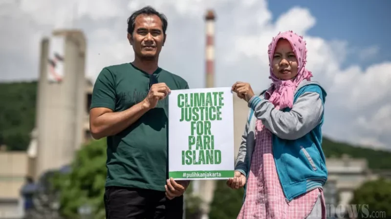 Warga pulau Pari Edi (kiri) dan Asmania berfoto di sebelah pabrik raksasa semen Swiss Holcim di Eclepens, Swiss barat (dok Tribunnews)