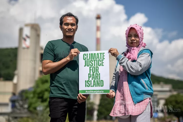 Warga pulau Pari Edi (kiri) dan Asmania berfoto di sebelah pabrik raksasa semen Swiss Holcim di Eclepens, Swiss barat (dok Tribunnews)