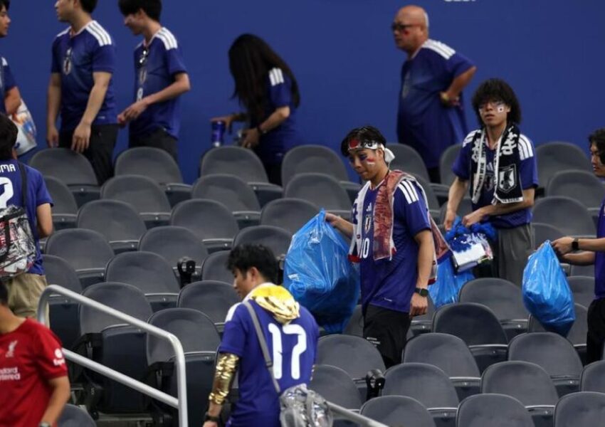 Suporter Jepang membersihkan stadion