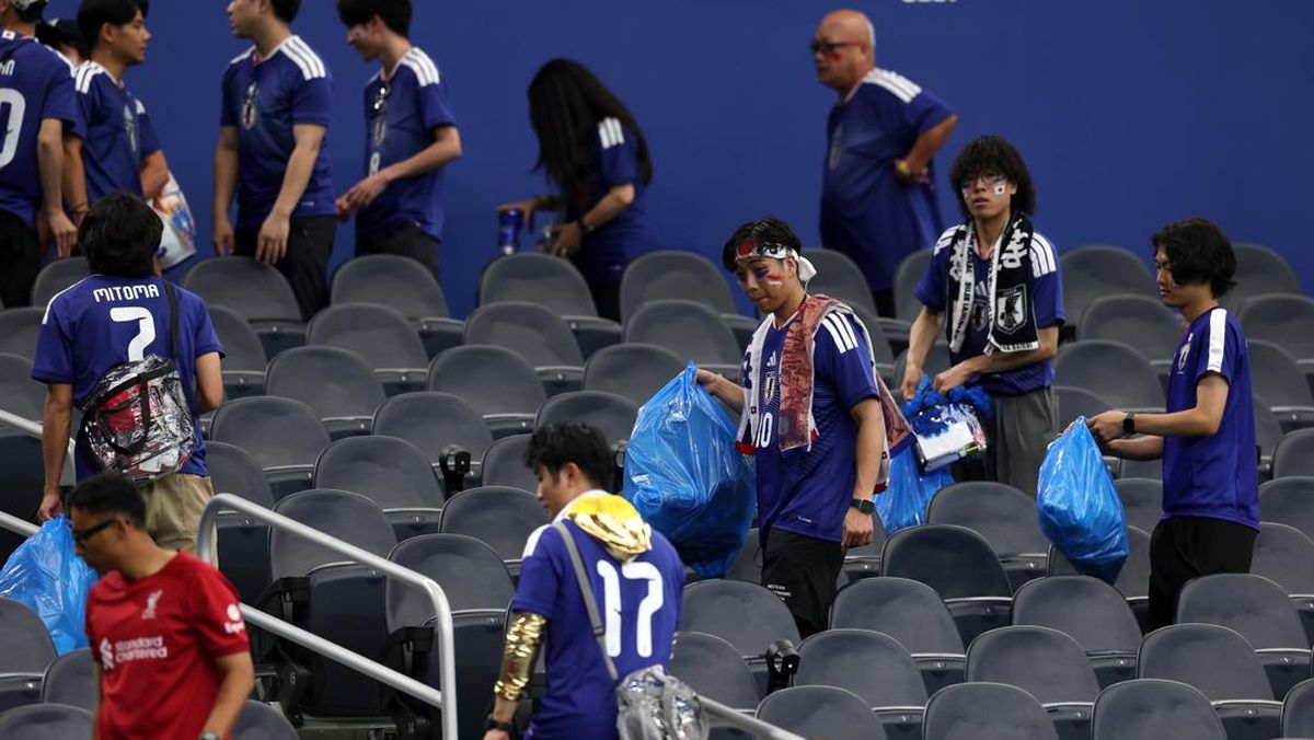 Suporter Jepang membersihkan stadion